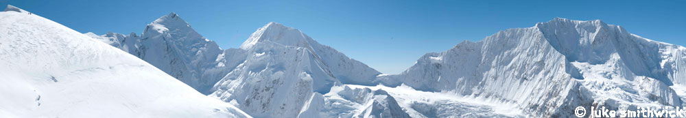 All of Himlung Himal on a bright Autumn day, climbers high on the mountain move towards Camp 3 (top left).